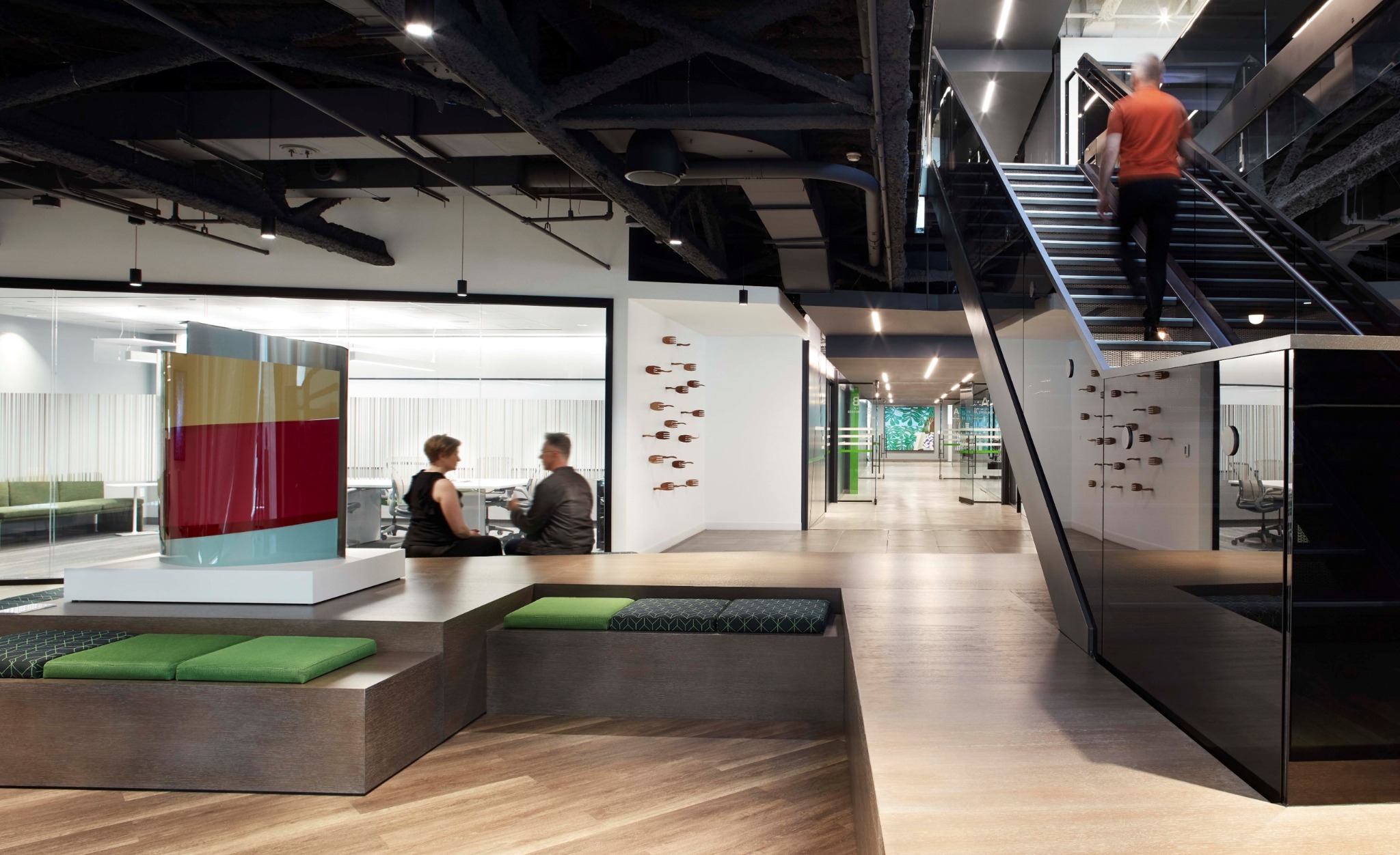 Artworks integrated into a workplace, beside a seating area and staircase
